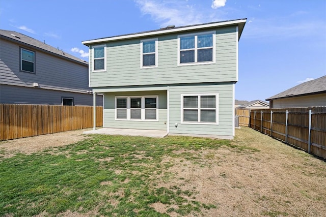 rear view of house with a fenced backyard and a yard