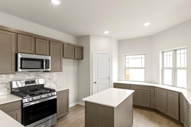 359 Witchhazel Way, San Marcos, TX 78666 - kitchen featuring stainless steel appliances, light wood finished floors, tasteful backsplash, light countertops, and recessed lighting