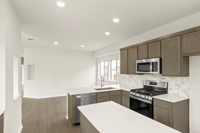 359 Witchhazel Way, San Marcos, TX 78666 - kitchen with stainless steel appliances, a sink, a peninsula, backsplash, and light countertops