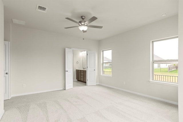 359 Witchhazel Way, San Marcos, TX 78666 - unfurnished bedroom featuring light carpet, baseboards, ensuite bathroom, and a ceiling fan