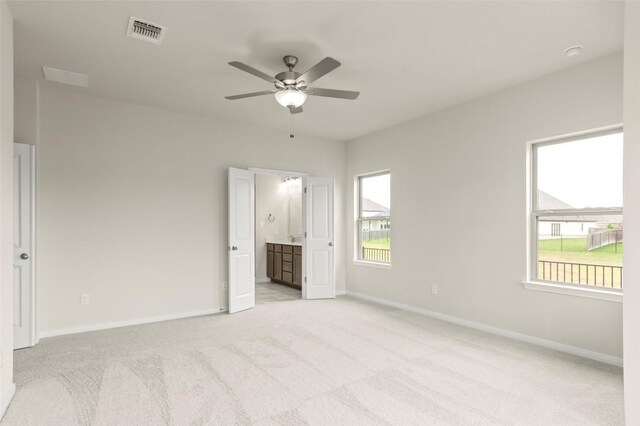 359 Witchhazel Way, San Marcos, TX 78666 - unfurnished bedroom with light carpet, ensuite bathroom, and ceiling fan