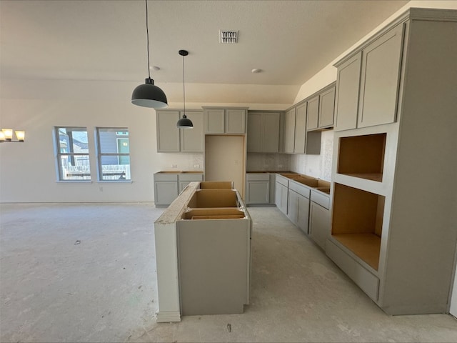 kitchen featuring visible vents, pendant lighting, gray cabinets, a center island, and concrete floors