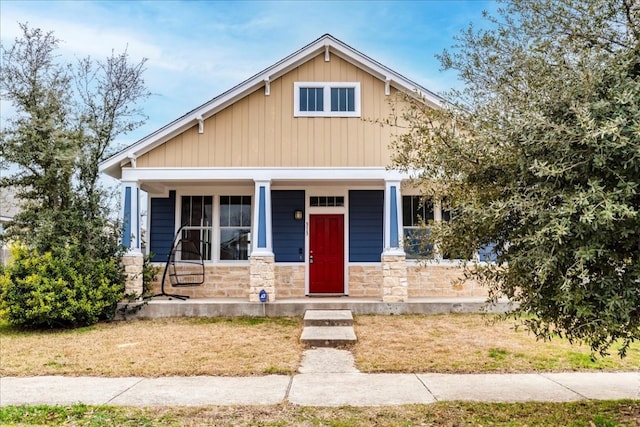 view of front of house featuring stone siding and a porch