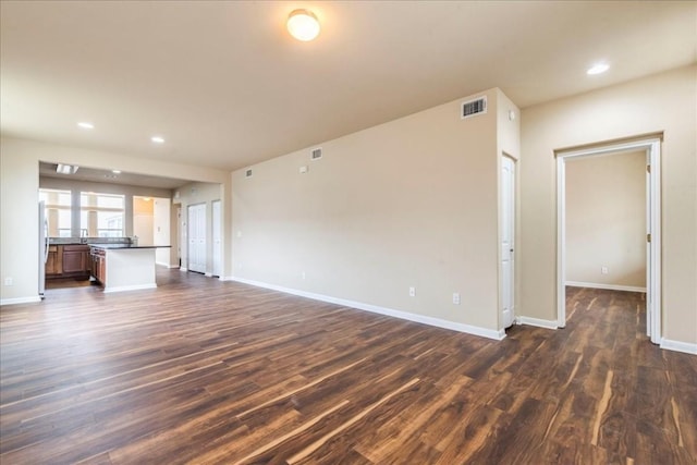 unfurnished living room featuring dark wood-style floors, recessed lighting, visible vents, and baseboards