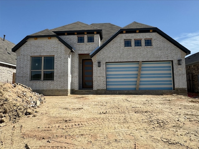 view of front of property featuring a garage and brick siding