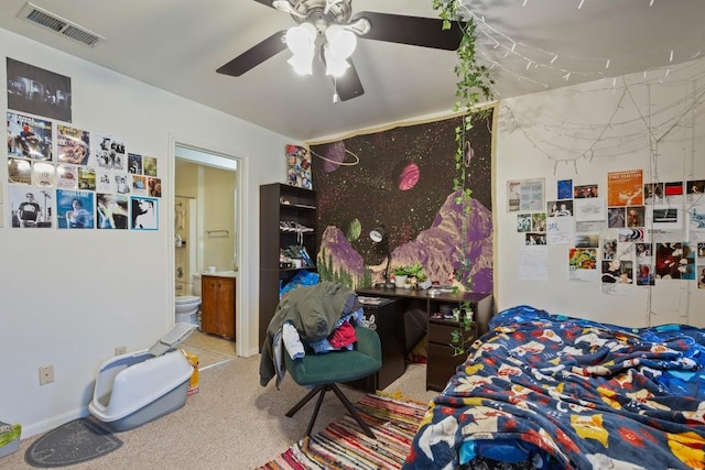 bedroom featuring a ceiling fan, visible vents, connected bathroom, and light carpet