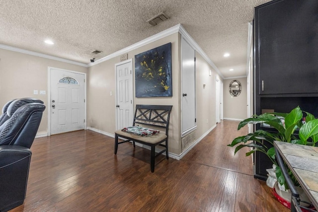 entrance foyer featuring wood-type flooring, visible vents, and crown molding