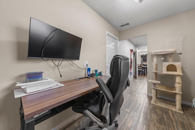 home office with baseboards, visible vents, and wood finished floors