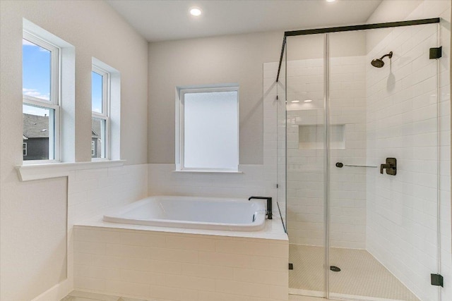 full bathroom featuring a bath, a shower stall, and recessed lighting