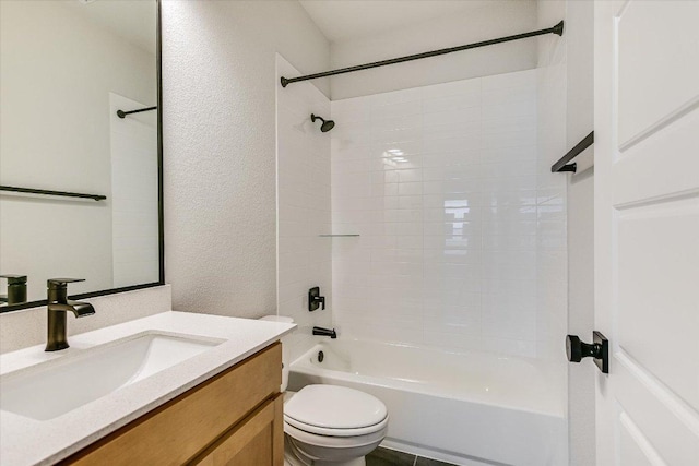 bathroom featuring toilet, a textured wall, vanity, and bathing tub / shower combination