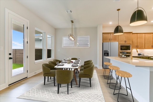 dining area featuring light wood-style flooring, recessed lighting, and baseboards