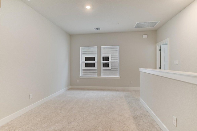 empty room featuring light carpet, baseboards, and recessed lighting