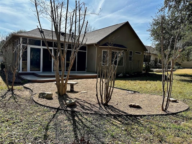 rear view of house featuring a sunroom, a patio area, and a yard