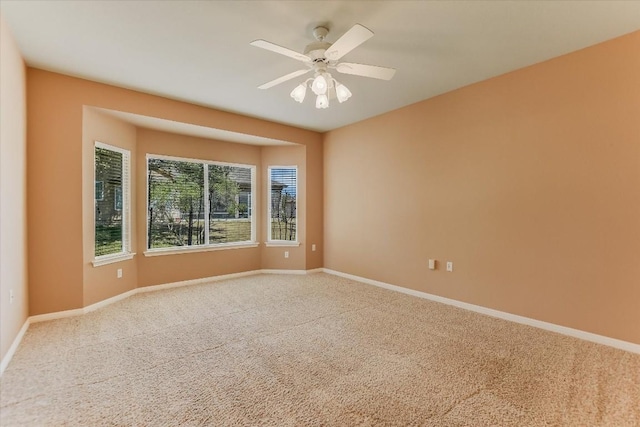 spare room with carpet floors, baseboards, and a ceiling fan