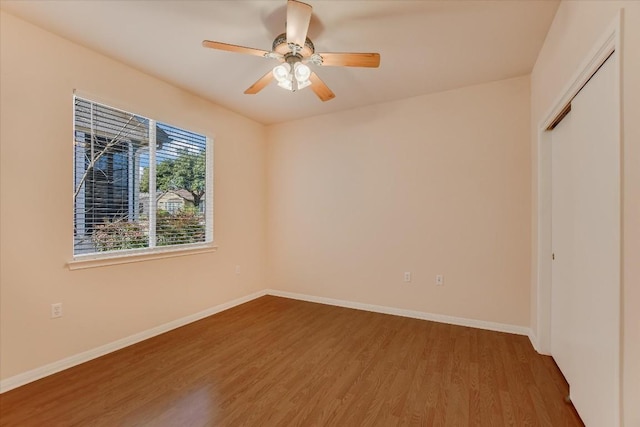 unfurnished bedroom with a closet, baseboards, and wood finished floors