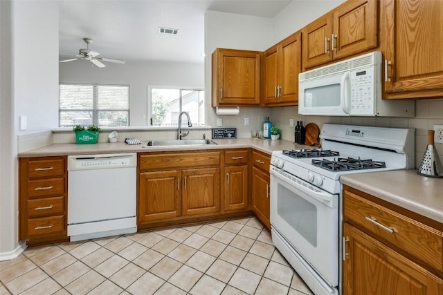 kitchen featuring light countertops, backsplash, brown cabinetry, a sink, and white appliances