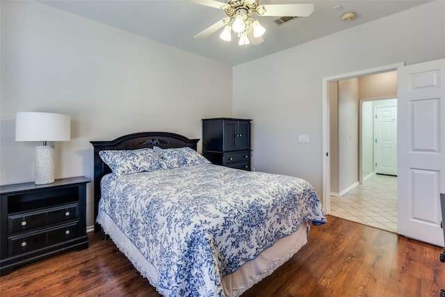 bedroom featuring dark wood-style floors, visible vents, baseboards, and a ceiling fan