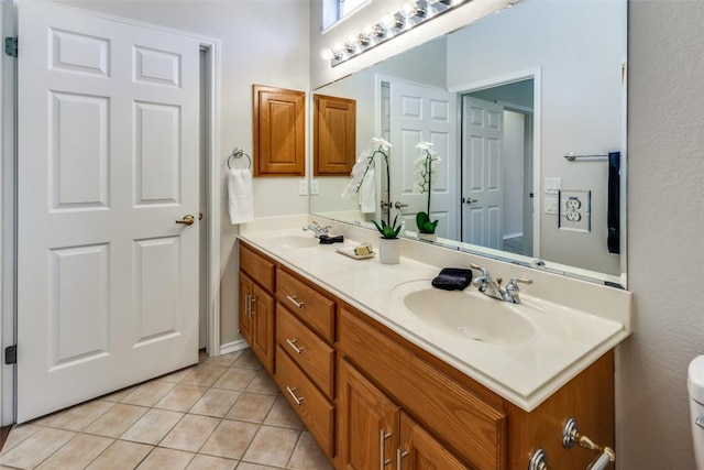 bathroom with tile patterned flooring, a sink, and double vanity