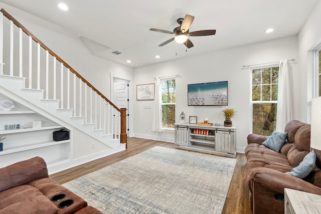 living room featuring baseboards, visible vents, wood finished floors, stairs, and recessed lighting