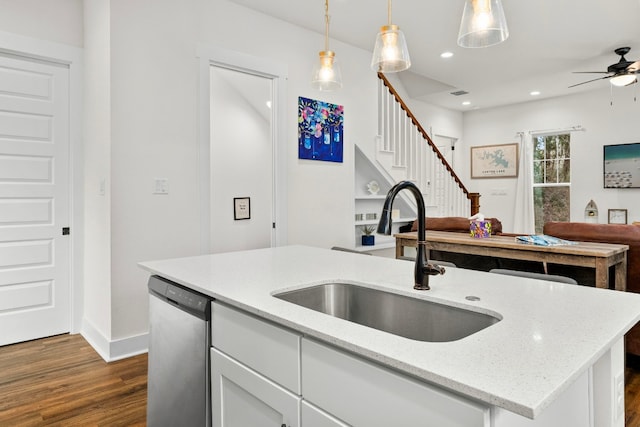 kitchen with light stone counters, a sink, white cabinets, dishwasher, and pendant lighting