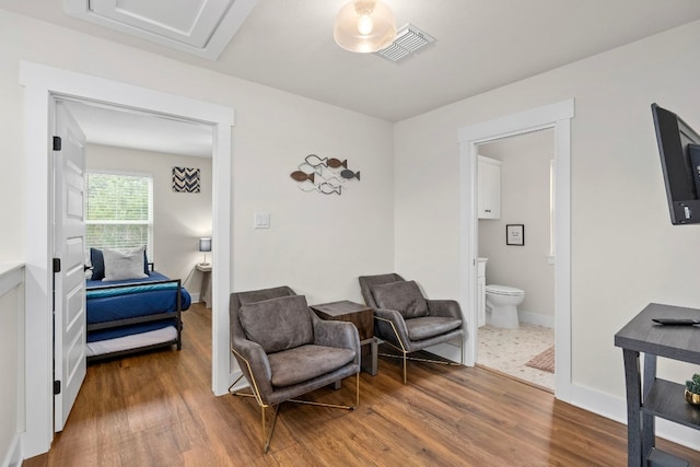 sitting room featuring baseboards, visible vents, and dark wood finished floors