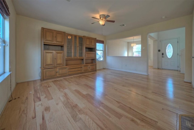 unfurnished living room with baseboards, ceiling fan, visible vents, and light wood finished floors