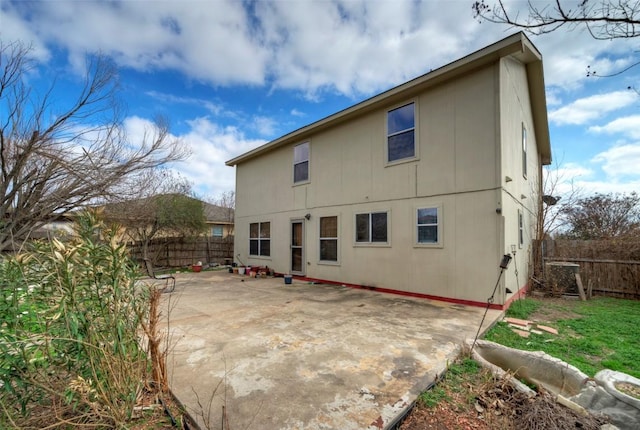 back of house with a fenced backyard and a patio