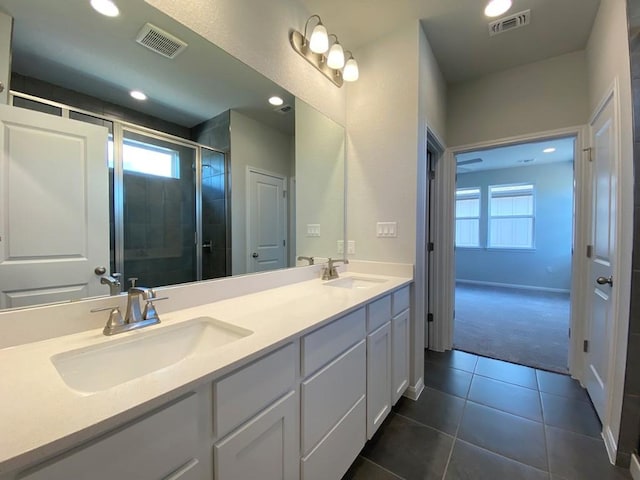 bathroom with double vanity, visible vents, and a sink