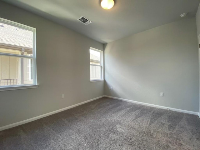 carpeted spare room with baseboards and visible vents