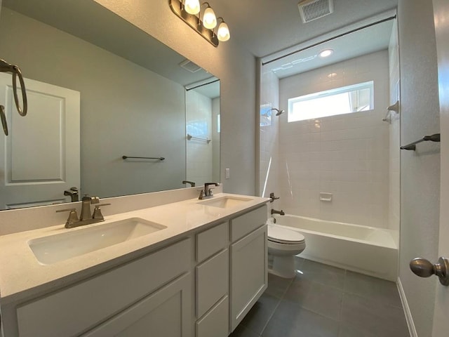 bathroom featuring tile patterned flooring, visible vents, a sink, and bathing tub / shower combination