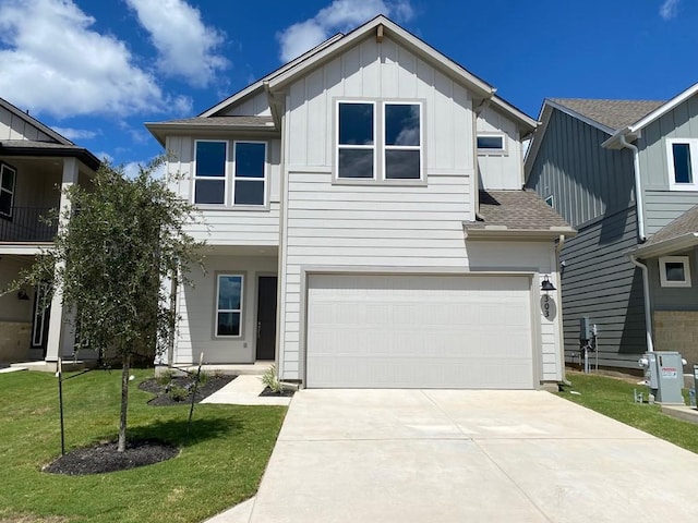 view of front of property with a garage, concrete driveway, roof with shingles, a front lawn, and board and batten siding