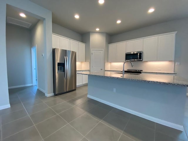 kitchen with stainless steel appliances, white cabinets, a sink, and tasteful backsplash