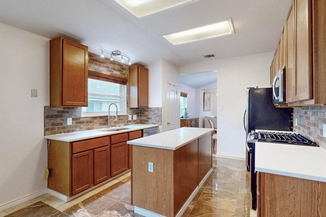 kitchen featuring visible vents, a center island, marble finish floor, stainless steel appliances, and a sink
