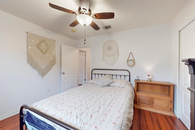 bedroom with visible vents, dark wood finished floors, and a ceiling fan