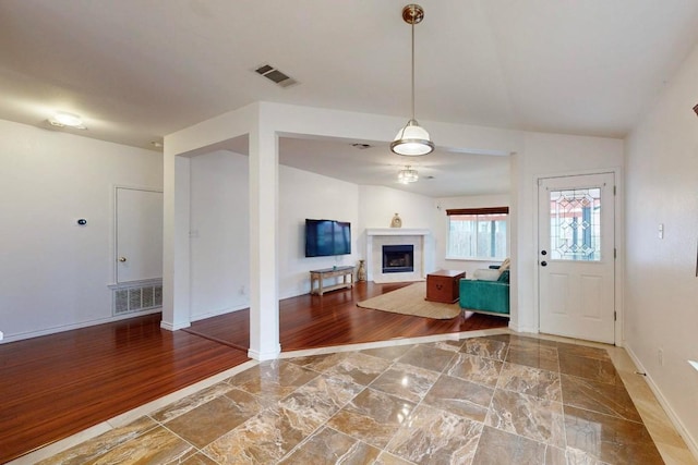 foyer featuring a fireplace, wood finished floors, and visible vents