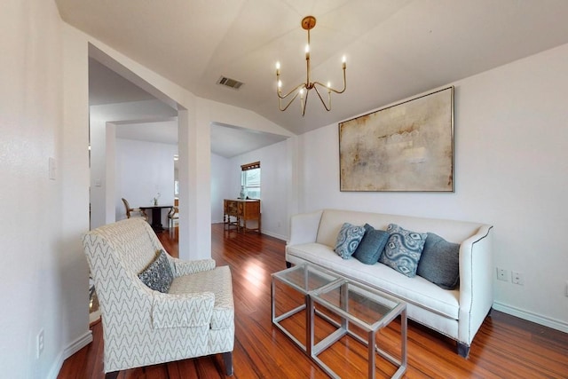 living area with baseboards, visible vents, lofted ceiling, wood finished floors, and an inviting chandelier