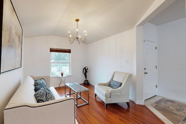 living area with lofted ceiling, wood finished floors, baseboards, and a chandelier