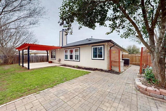 rear view of property with a chimney, a patio area, a fenced backyard, and a pergola