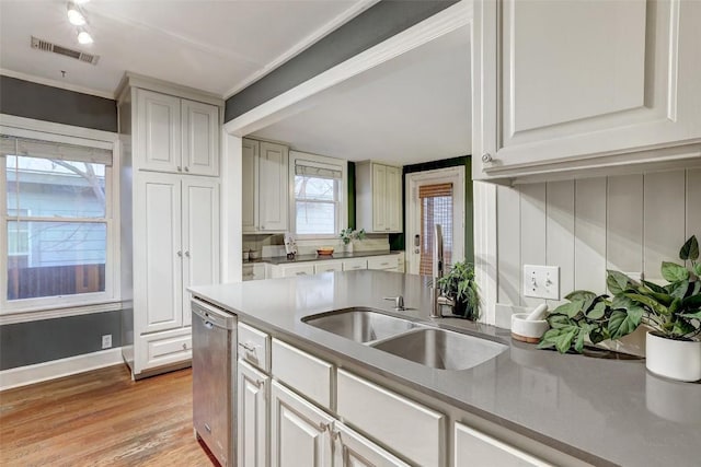 kitchen featuring visible vents, white cabinets, light countertops, light wood-type flooring, and dishwasher