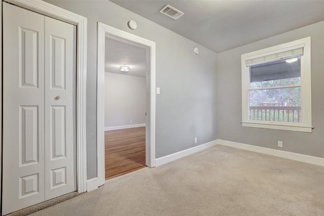 unfurnished room with light carpet, baseboards, and visible vents