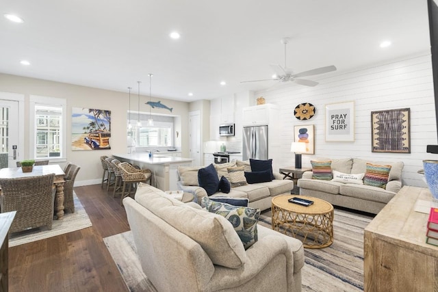 living area featuring dark wood-style floors, plenty of natural light, baseboards, and recessed lighting