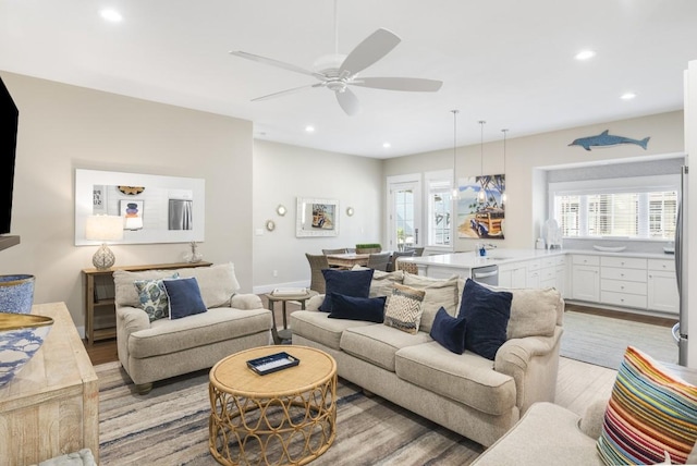 living area featuring light wood-style flooring, a ceiling fan, and recessed lighting