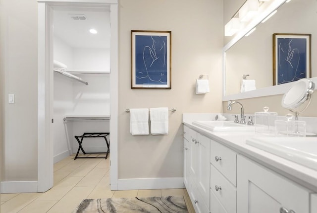 full bath featuring tile patterned flooring, a sink, visible vents, a spacious closet, and double vanity