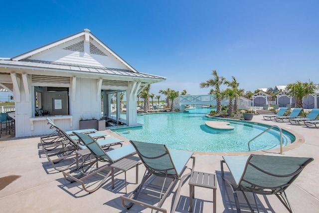 community pool featuring exterior bar and a patio