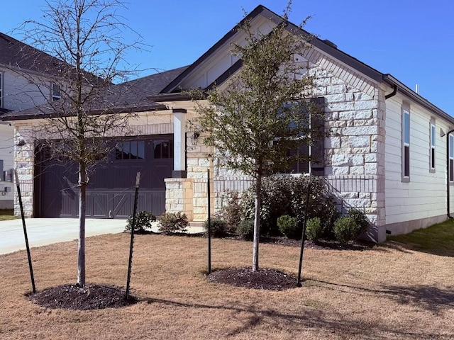 view of side of property with driveway and a garage