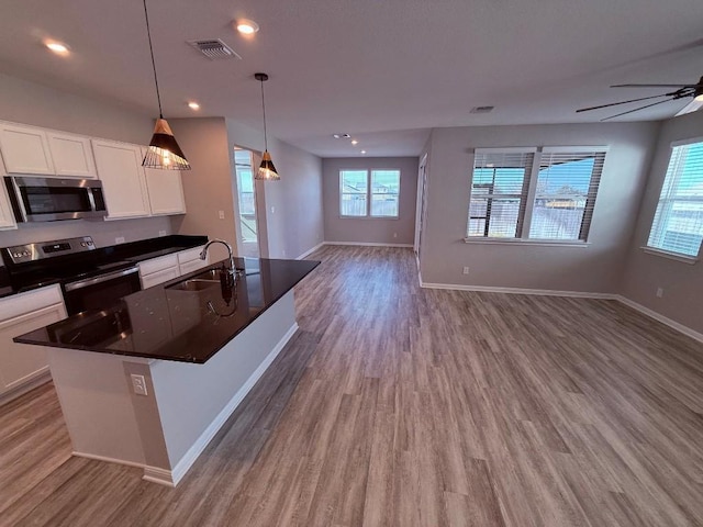 kitchen featuring open floor plan, appliances with stainless steel finishes, a sink, and visible vents