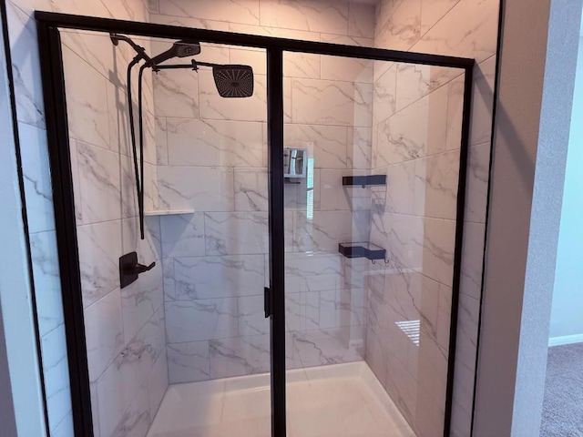 bathroom featuring a marble finish shower