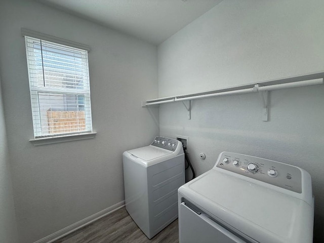 clothes washing area featuring laundry area, independent washer and dryer, dark wood finished floors, and baseboards