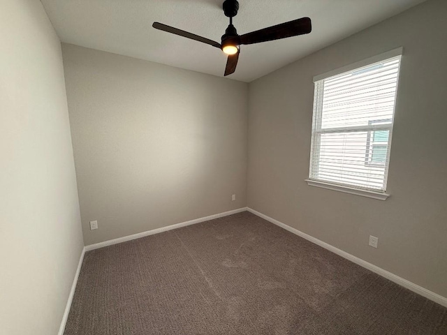 carpeted empty room with a ceiling fan and baseboards