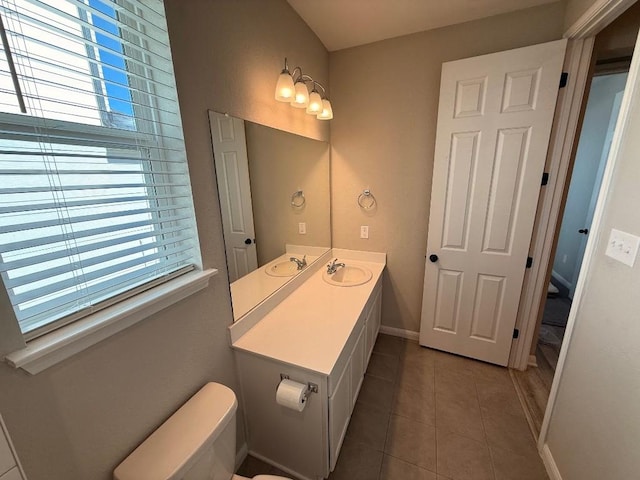 half bath featuring toilet, tile patterned flooring, baseboards, and vanity